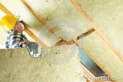 Man installing thermal roof insulation layer - using mineral woo Stock Photo