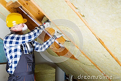 Man installing thermal roof insulation layer - using mineral woo Stock Photo