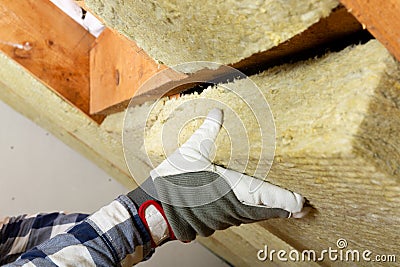 Man installing thermal roof insulation layer - using mineral woo Stock Photo