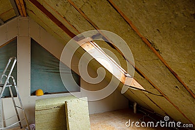 Man installing thermal roof insulation layer - using mineral woo Stock Photo