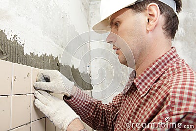 Man installs ceramic tile Stock Photo