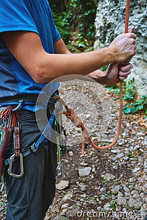 A man insures climber through a belay device. Stock Photo