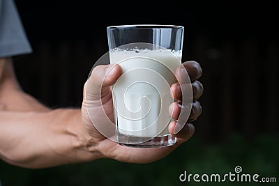 Man invites everyone to strengthen with calcium, holding a milk glass Stock Photo