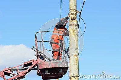 Man ironworker repairing trolleybus rigging standing on a truck mounted lift. Kyiv, Ukraine Editorial Stock Photo