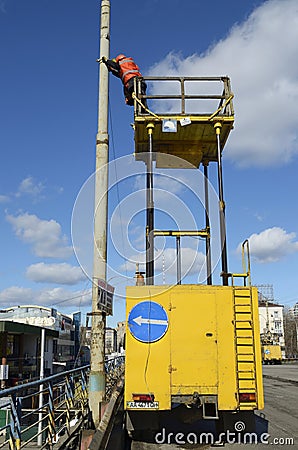 Man ironworker repairing trolleybus rigging standing on a truck mounted lift Stock Photo