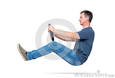 Man in jeans and t-shirt drives a car with a steering wheel, isolated on white background. Auto driver concept Stock Photo