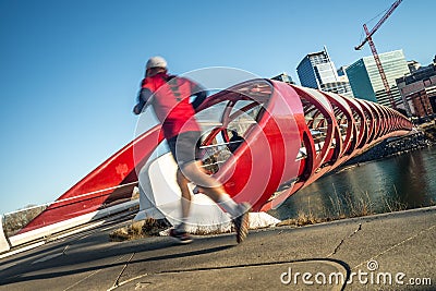 Man jogging beside bridge in city downown Stock Photo