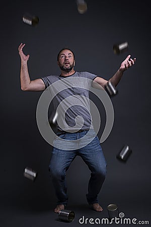 A man juggles with empty cans. Stock Photo