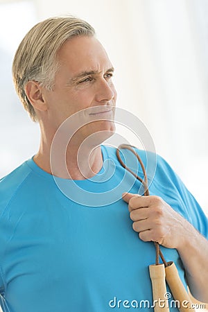 Man With Jump Rope Looking Away In Health Club Stock Photo