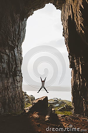 Man jumping in cave Travel adventure vacations happy emotions Stock Photo