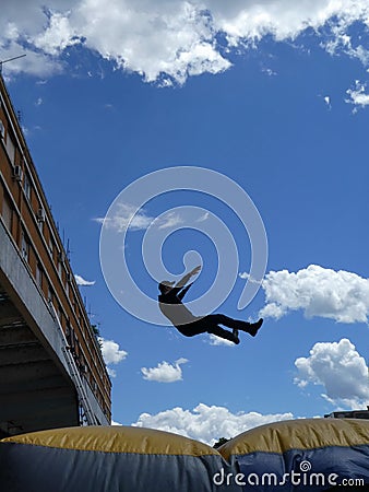 Man jumping down to the Inflatable Rescue Cushion also known as a Jump Cushion or Air Cushion Editorial Stock Photo