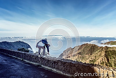 Man jumping high up on a mountain hike. Stock Photo