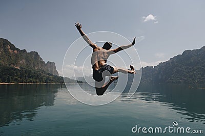 Man jumping with joy by a lake Stock Photo