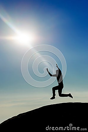 Man jumping on mountain peak silhouette Stock Photo