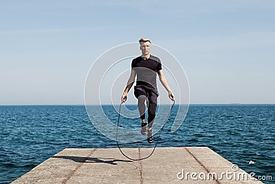 Man with jumping rope on pier Stock Photo