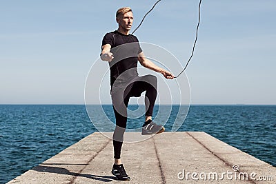 Man jumping rope on waterfront Stock Photo