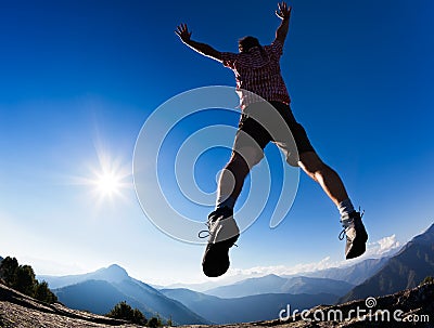 Man jumping in the sunshine against blue sky Stock Photo