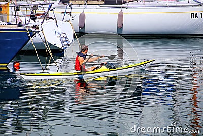 Man kayaking along the boats at Trieste marina, Italy Editorial Stock Photo