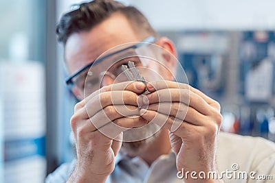 Man at key cutter shop looking at blanks Stock Photo