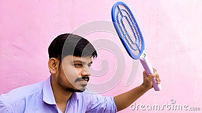 Man killing Bug mosquitos using Zapper or Racket Stock Photo