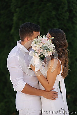 Man kiss woman and hide by bouquet. Wedding day Stock Photo