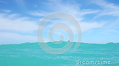 Man Kite Boarding In Ocean. Slow motion shot of man kite surfing in ocean going past the camera Man Kite Boarding In Ocean. Slow motion shot of man kite surfing in ocean going past the camera