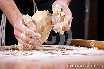 Man kneading dough on flour covered table Stock Photo