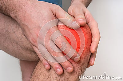 Man with knee pain is holding his aching leg Stock Photo