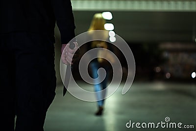 Man with knife following woman Stock Photo