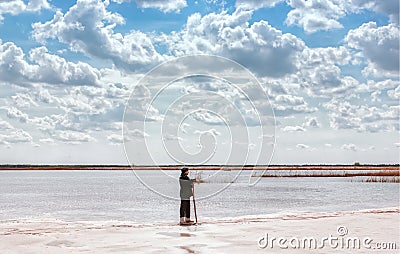 Man By The Lake Among Quartz Sand Under Beautiful Cloudy Sky Stock Photo