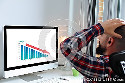 Man lamenting in front of computer with bad results data on the screen Stock Photo