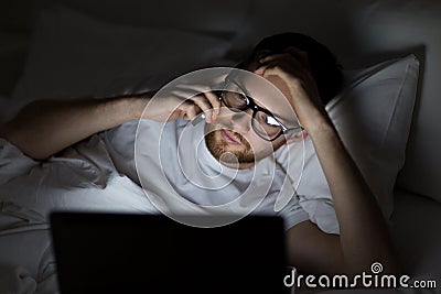 Man with laptop calling on smartphone at night Stock Photo