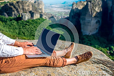 Man with laptop on the mountains Stock Photo