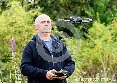 A man launching a drone on meadow Stock Photo