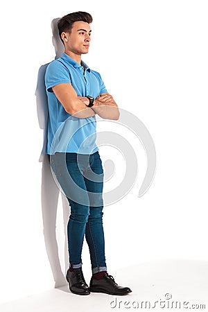 Man leaning against studio wall with hands crossed Stock Photo