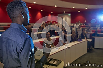 Man lecturing students in a university lecture theatre Stock Photo