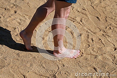 Man legs on sand. Male feet walking on beautiful sandy beach of hotel resort in Egypt, doing and leave footprints in sand. Stock Photo