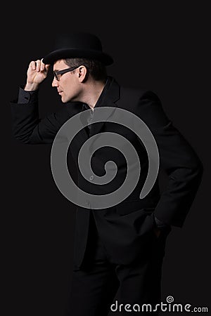 Man lifts a bowler hat in greeting. Stock Photo