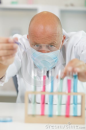 man lifts test-tube up at laboratory Stock Photo
