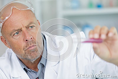 Man lifts test-tube up at laboratory Stock Photo