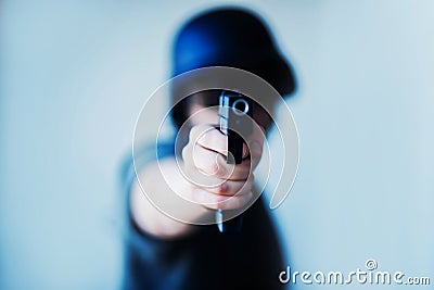 A man in a helmet holds a pistol in his hand and is about to shoot. Crime and murder. Military police. Airsoft and equipment Stock Photo