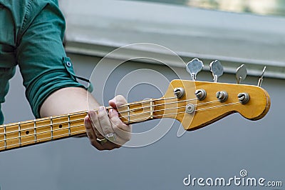Man in light shirt plays bass guitar. Stock Photo
