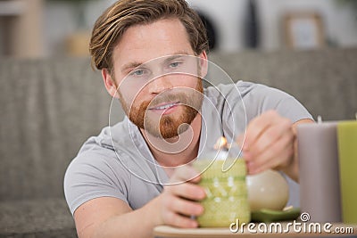 man lighting red candle hand close up Stock Photo