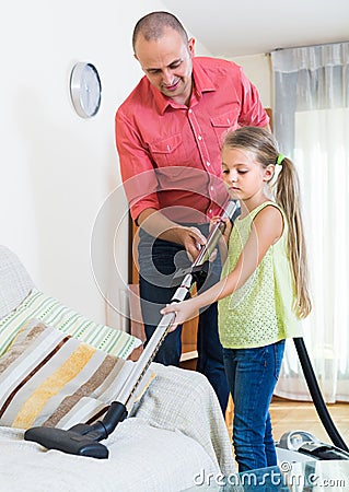 Man and little girl hoovering at home Stock Photo