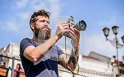 Man with long beard shooting photos. Manual settings. Photographer hold vintage camera. Modern blogger. Content creator Stock Photo