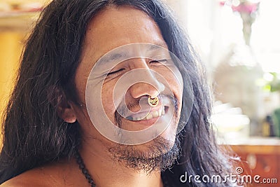 Man with long hair wearing a metal septum piercing at his nose Stock Photo