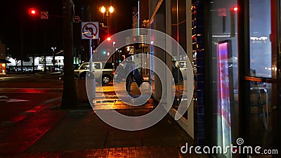 Man look like homeless walking, city street walkway at night. Male person on sidewalk California USA Editorial Stock Photo