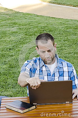 Man looking at a laptop outdoors. Stock Photo