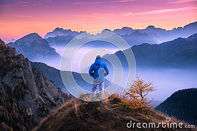 Man looking on mountain valley with low clouds at colorful sunset Stock Photo