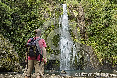 Man looking at scenic waterfall in New Zealand Stock Photo